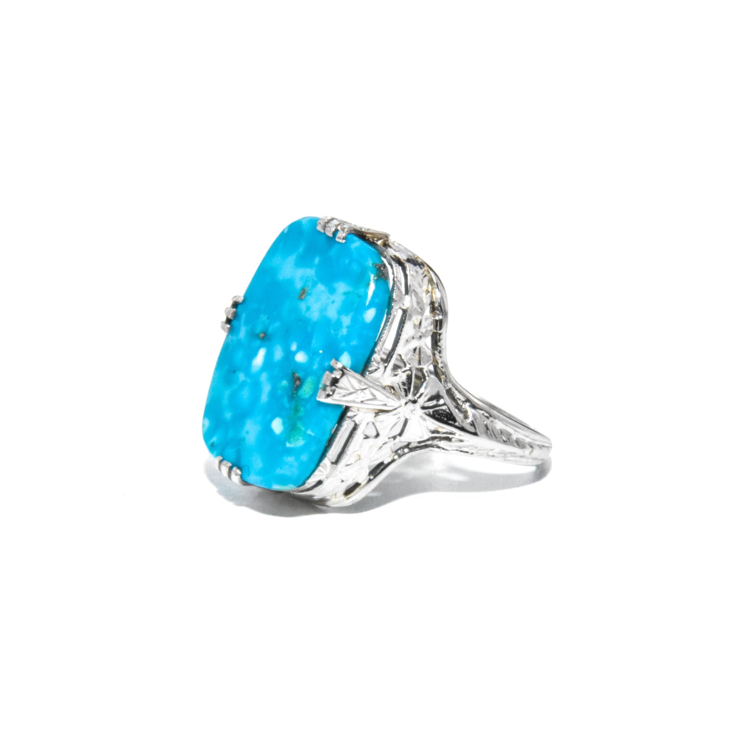 An Art Deco style 14K white gold ring with a large turquoise stone and intricate filigree design.