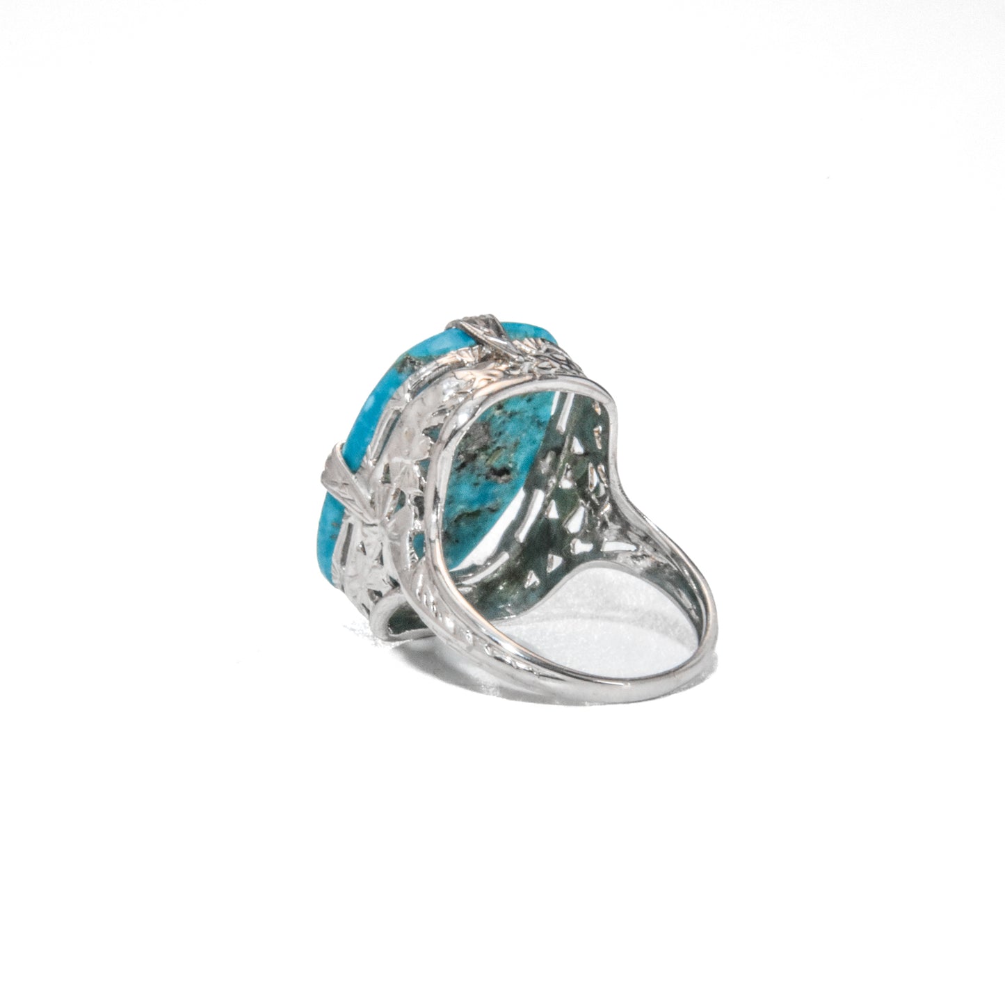 An Art Deco style 14K white gold ring with a large turquoise stone and intricate filigree design.
