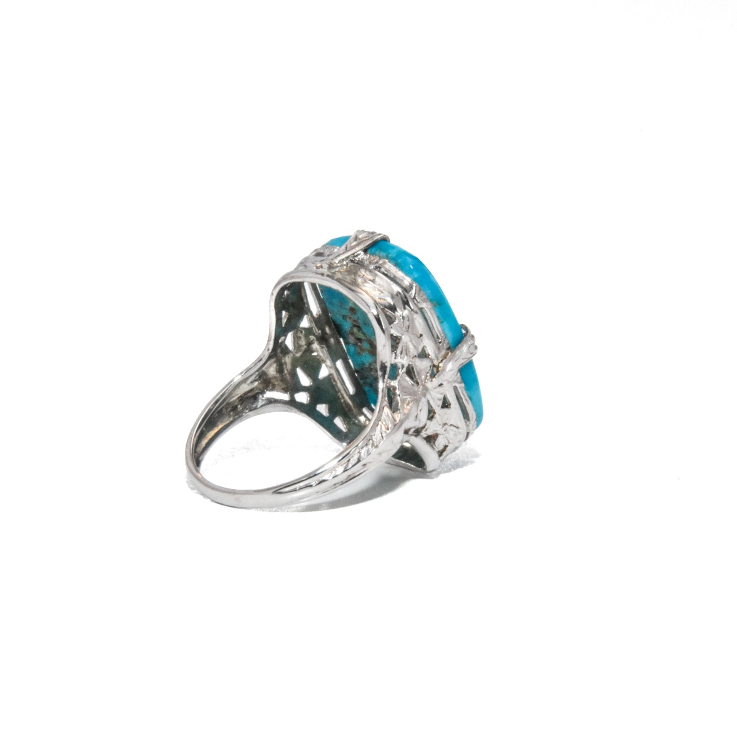 An Art Deco style 14K white gold ring with a large turquoise stone and intricate filigree design.