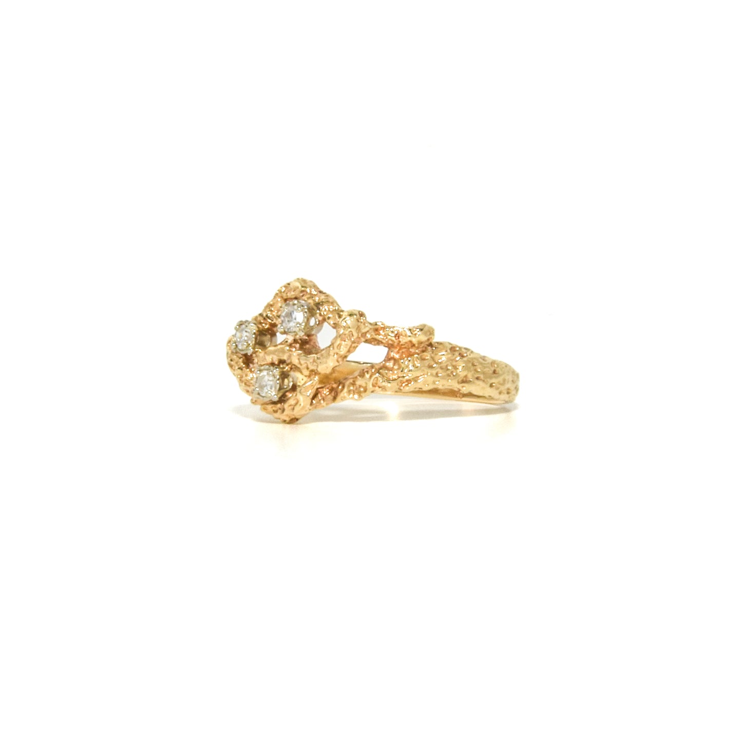 A vintage 14K gold Brutalist style ring with a textured design and three round-cut diamonds set within the gold structure.