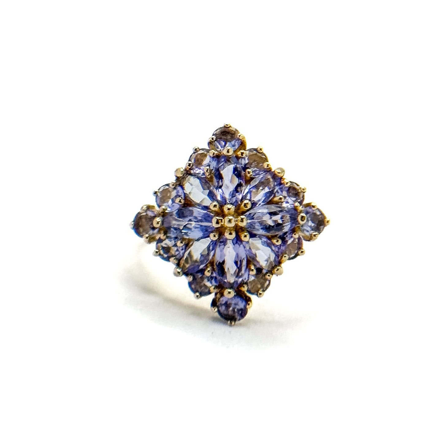A vintage 14k gold cluster ring with multiple tanzanite gemstones set in a floral pattern.
