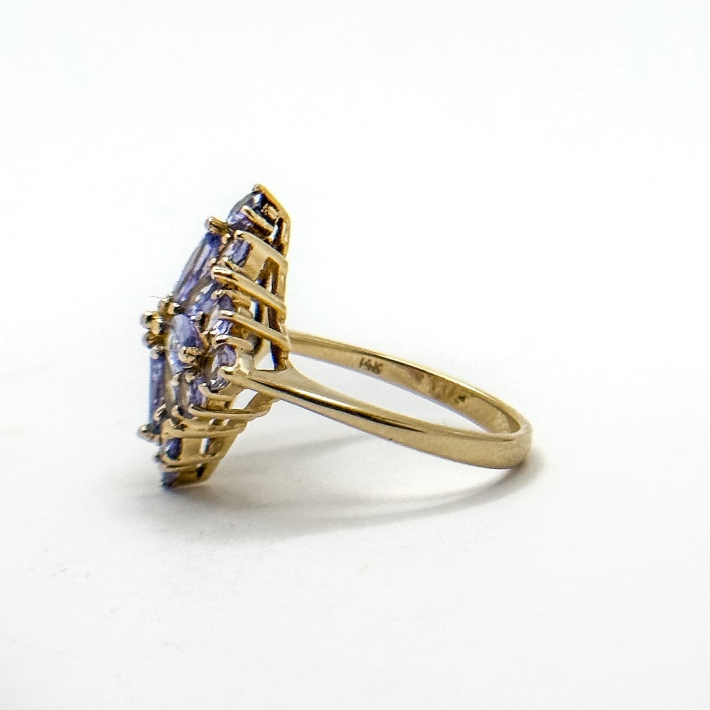 A vintage 14k gold cluster ring with multiple tanzanite gemstones set in a floral pattern.