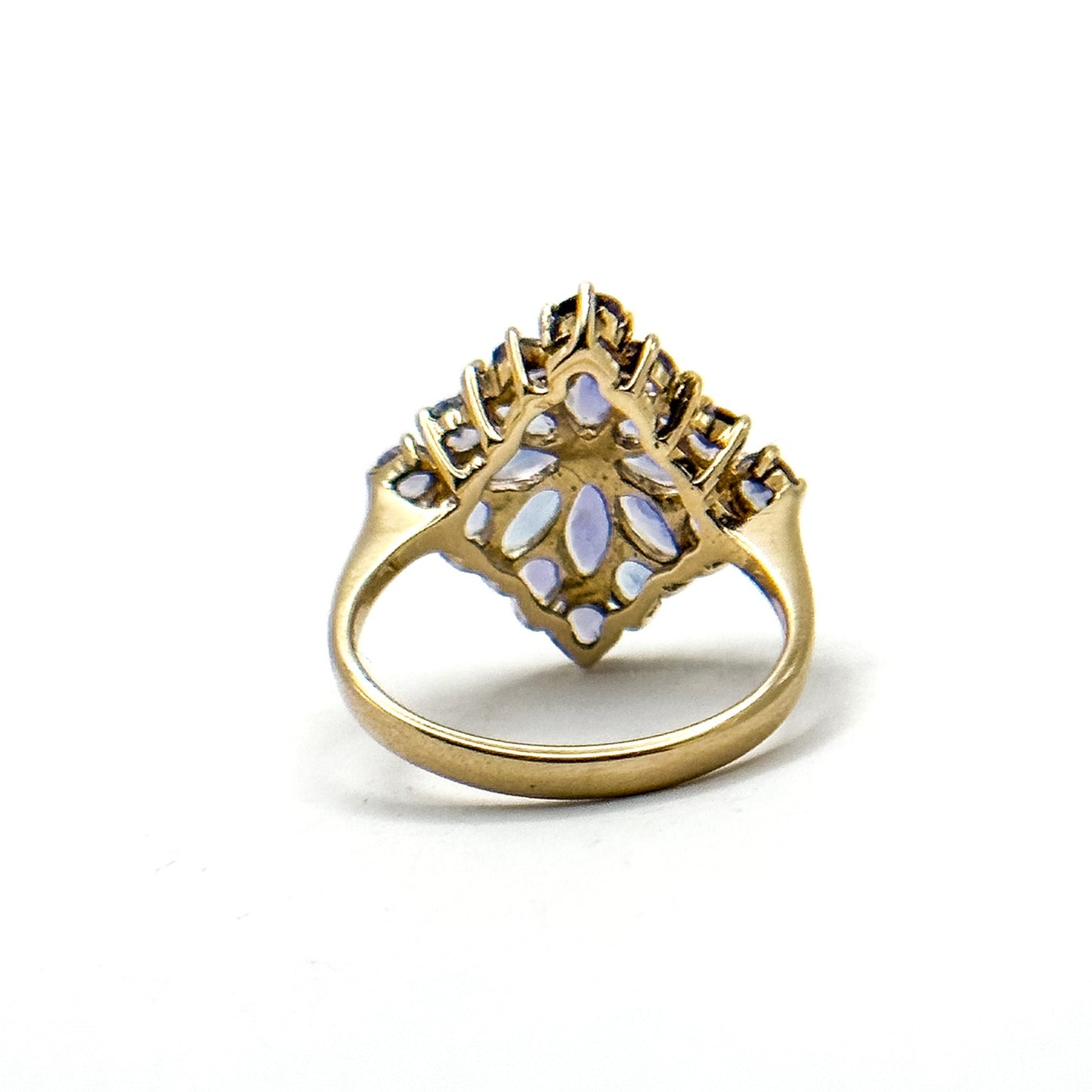 A vintage 14k gold cluster ring with multiple tanzanite gemstones set in a floral pattern.