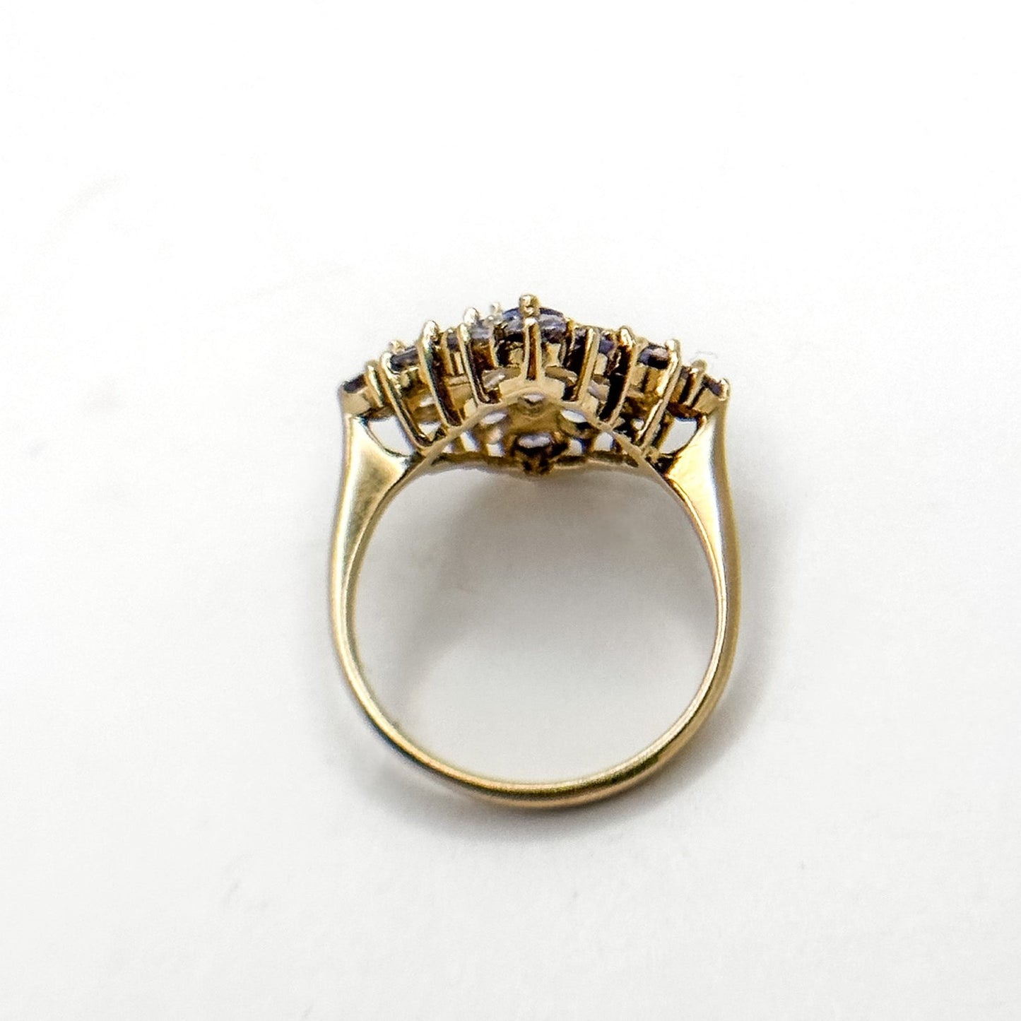 A vintage 14k gold cluster ring with multiple tanzanite gemstones set in a floral pattern.