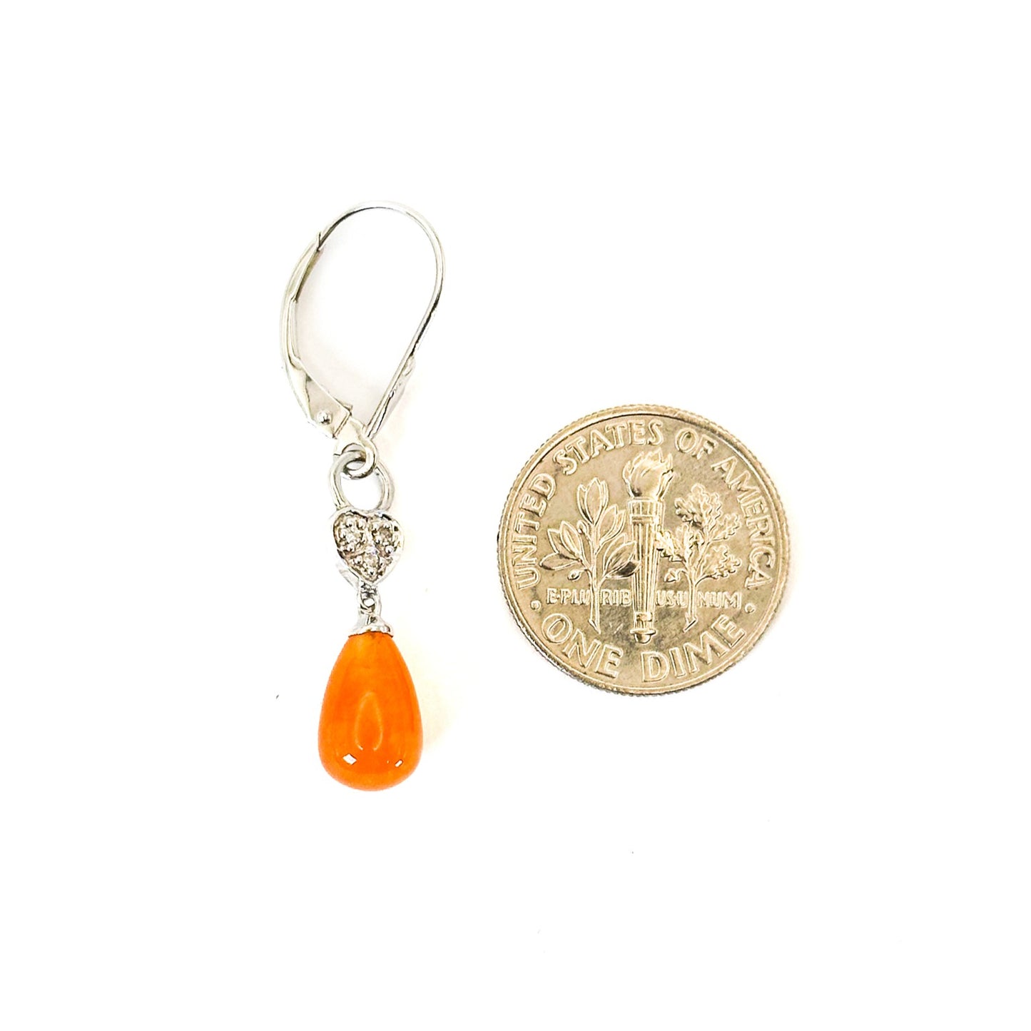 A pair of 14K white gold dangle lever-back earrings featuring teardrop-shaped fire opals with heart-shaped and diamond accents accents on a white background. Next to a US dime.