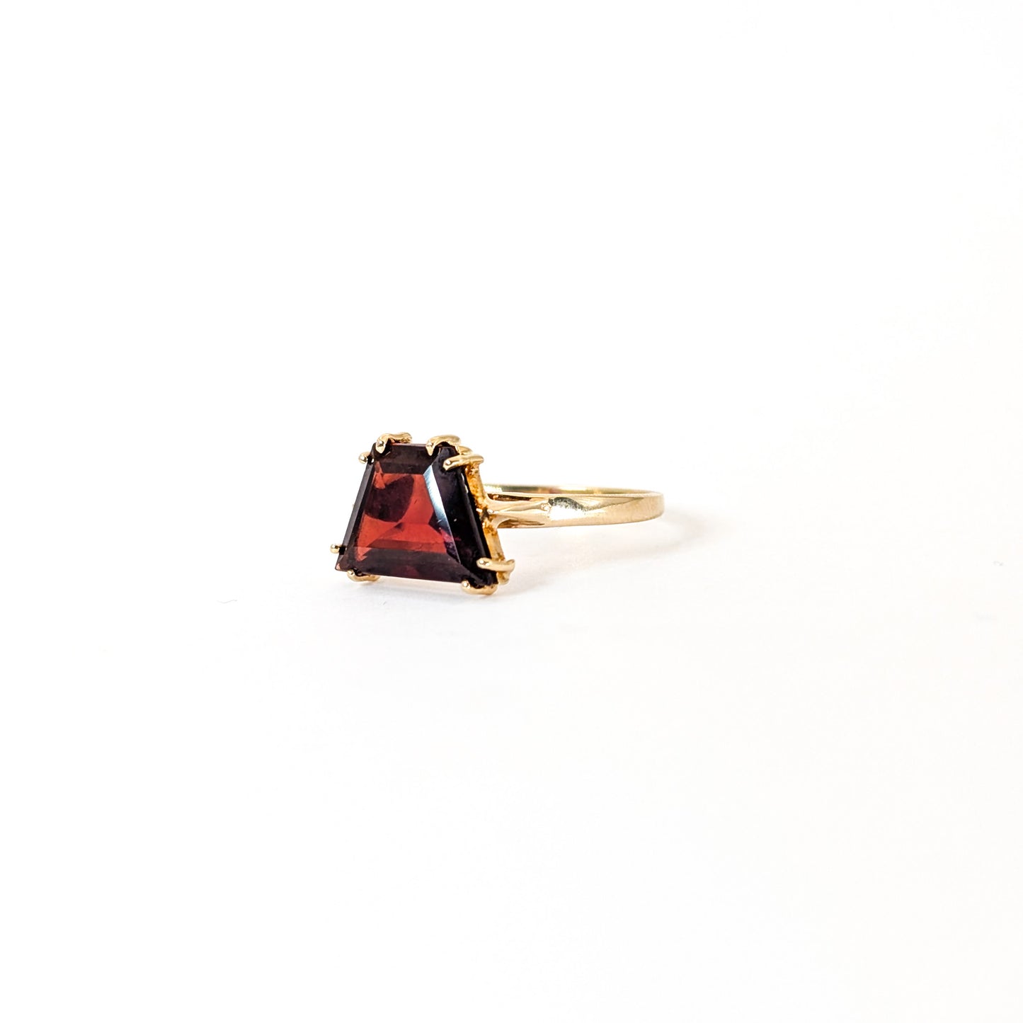 14K Gold garnet ring, cut into a striking trapezoid shape, on a white background