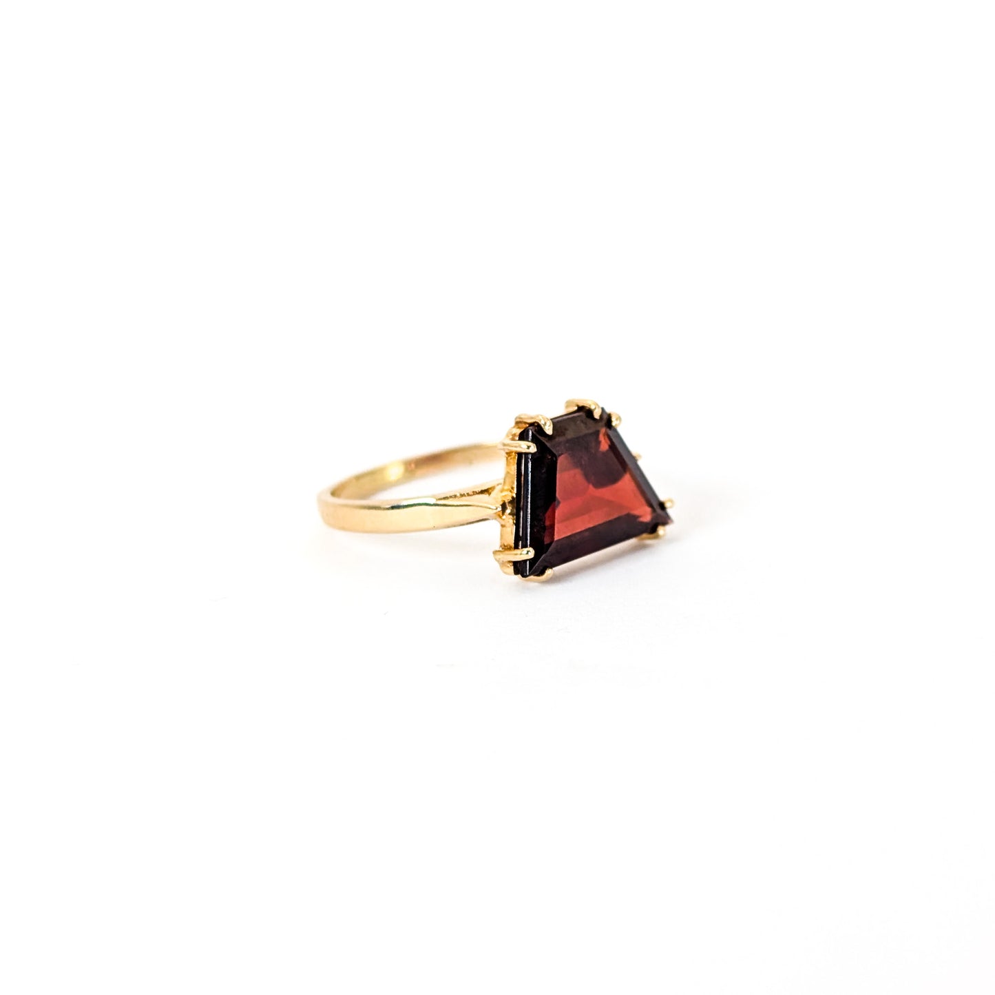 14K Gold garnet ring, cut into a striking trapezoid shape, on a white background