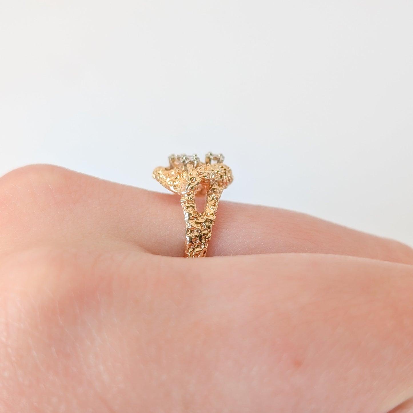 Gold ring on a finger against a white background