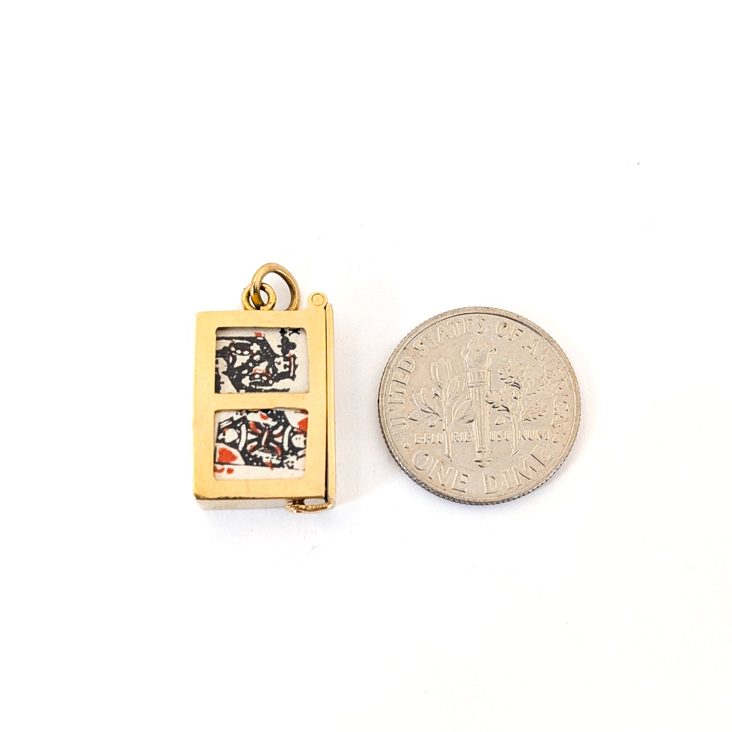 14k gold vintage mechanical charm with enameled card suit symbols and a real deck of cards on a white background