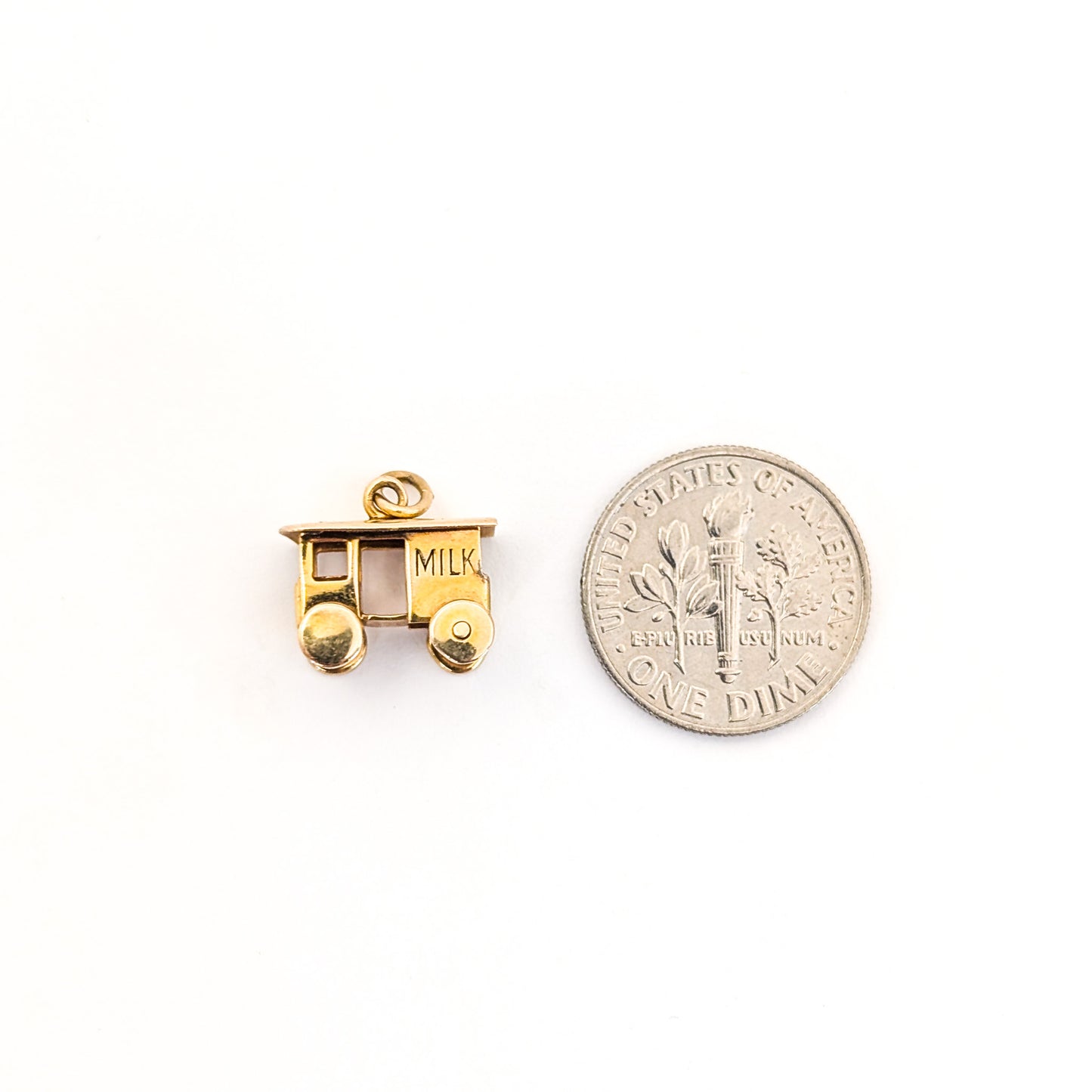 14K Gold milk cart mechanical charm next to a U.S. dime on a white background