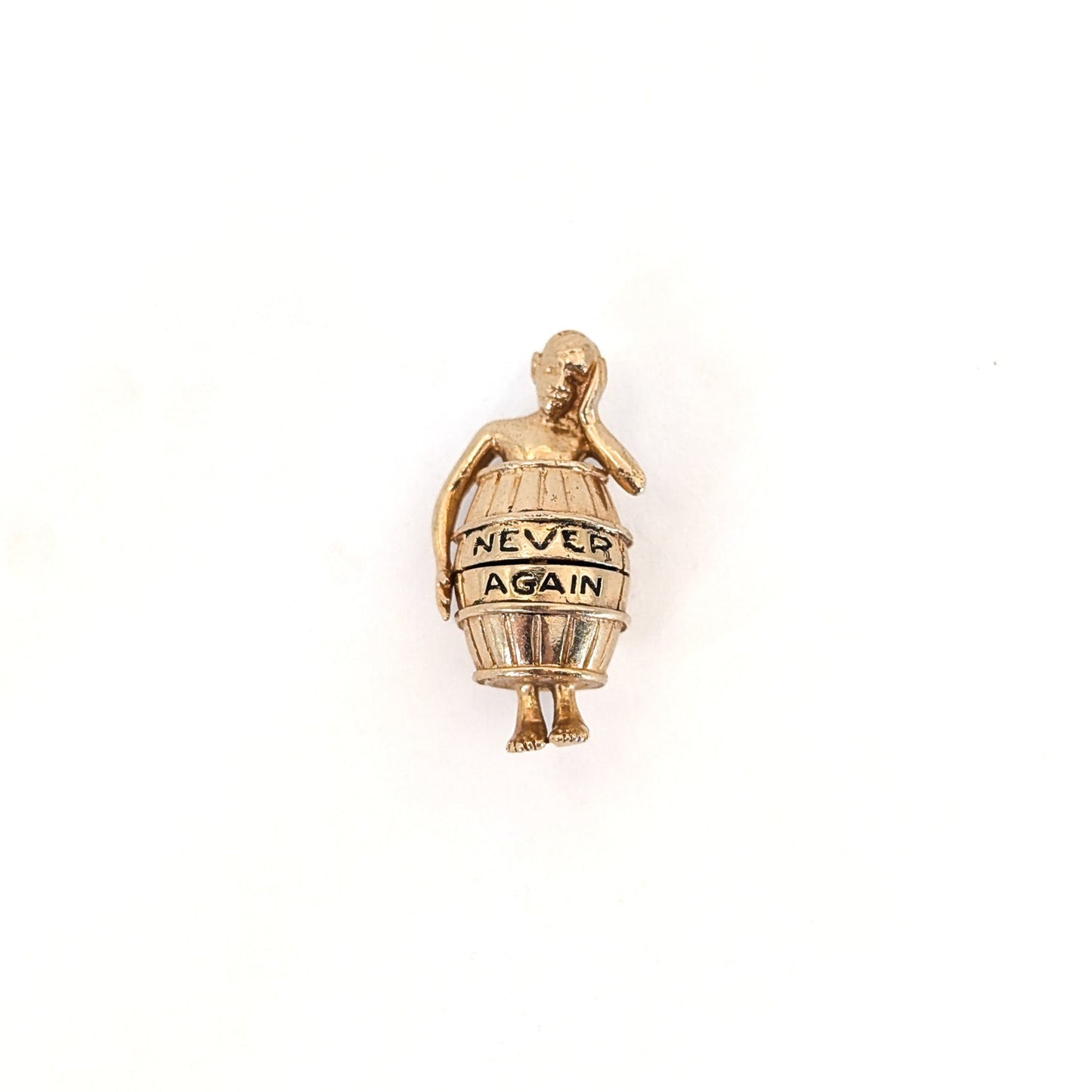 14K gold mechanical cram of a man in a barrel with 'Never Again' text on a white background