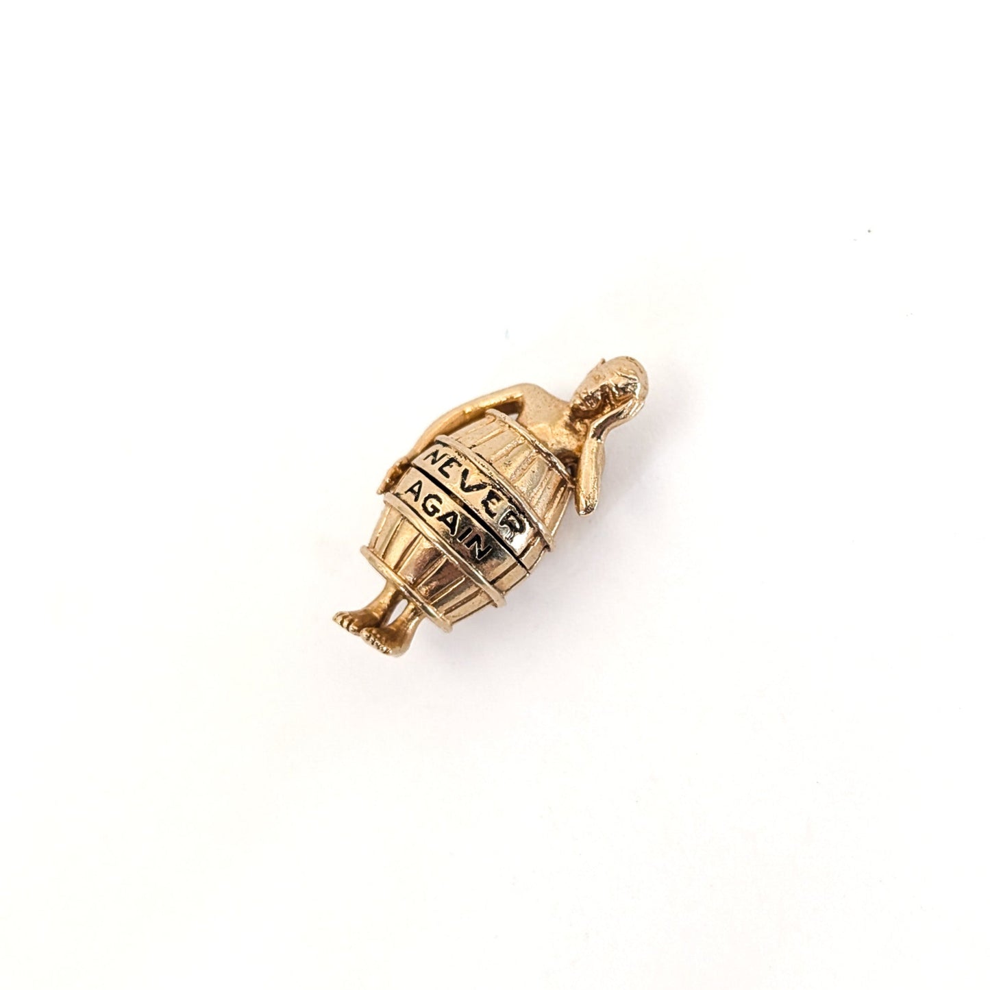 14K gold mechanical cram of a man in a barrel with 'Never Again' engraving on a white background