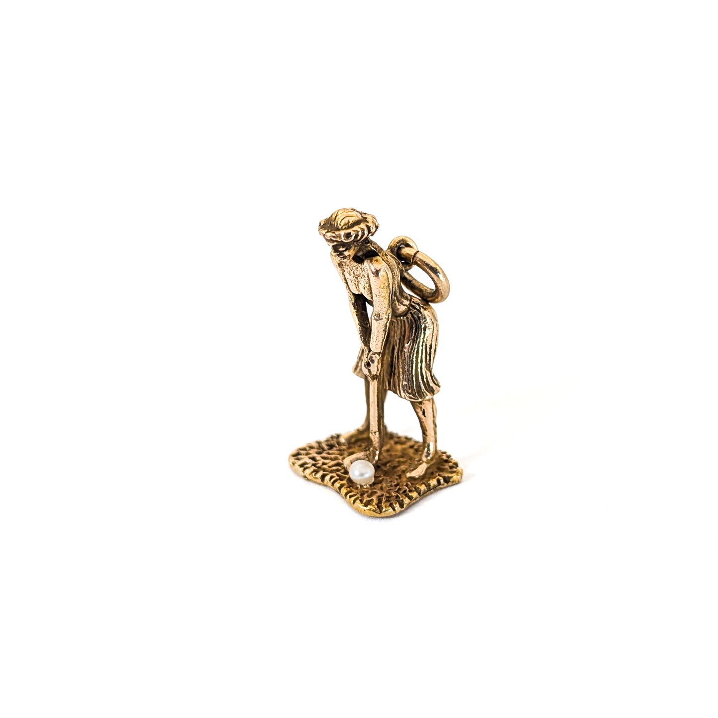 14k Gold vintage mechanical charm of lady playing golf with a pearl golf ball on a white background