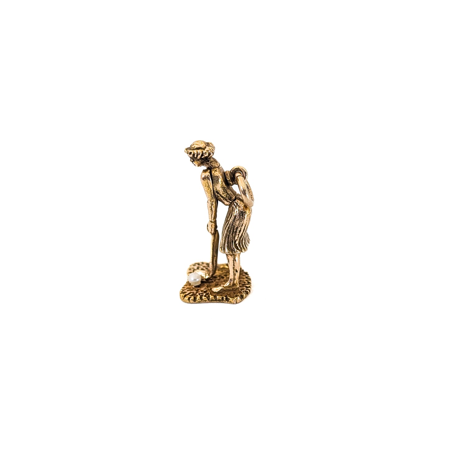14k Gold vintage mechanical charm of lady playing golf with a pearl golf ball on a white background