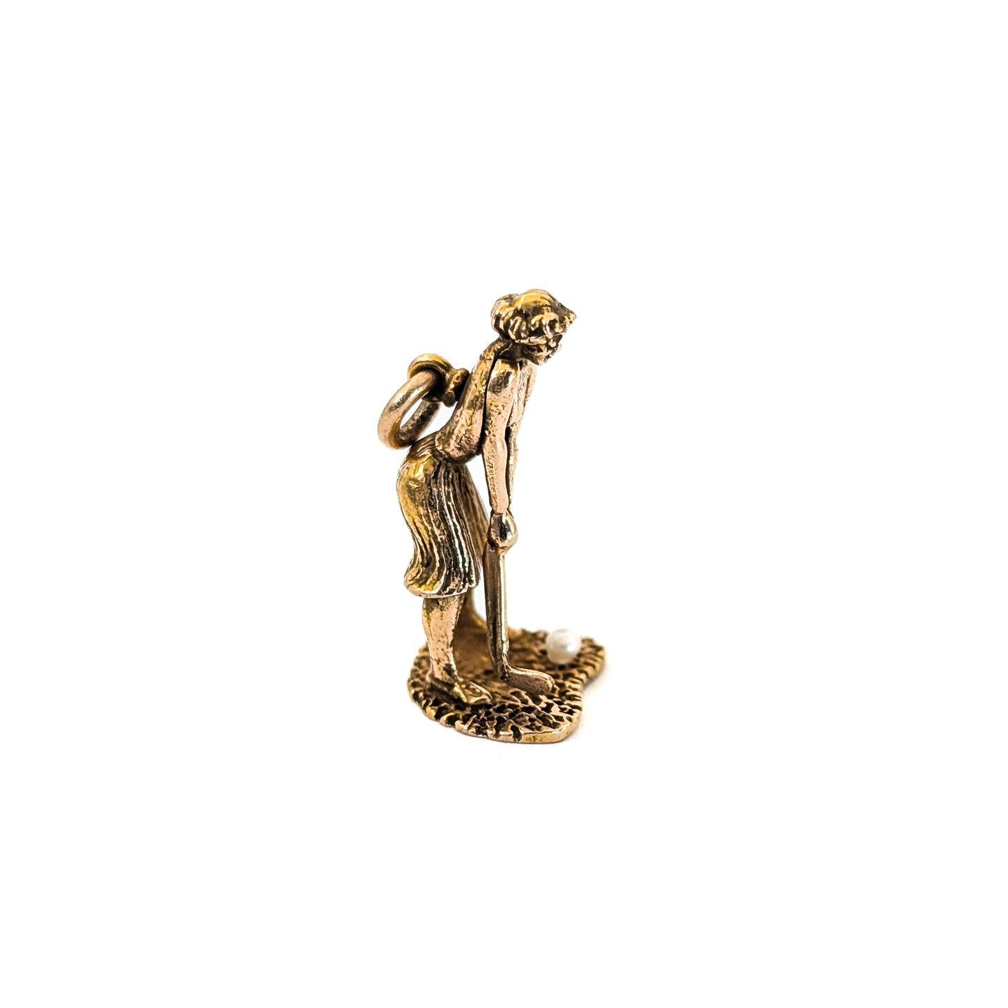 14k Gold vintage mechanical charm of lady playing golf with a pearl golf ball on a white background
