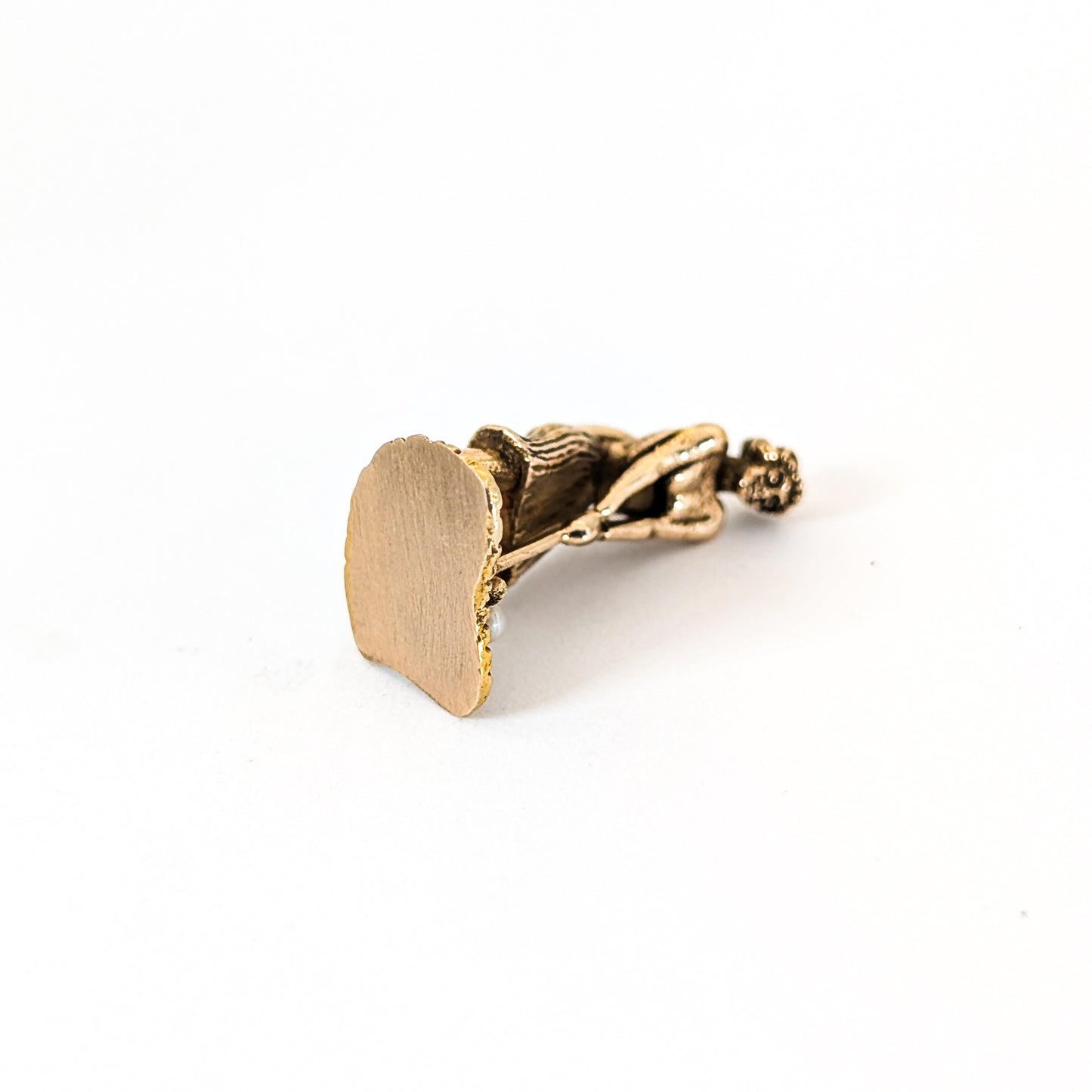 14k Gold vintage mechanical charm of lady playing golf with a pearl golf ball on a white background