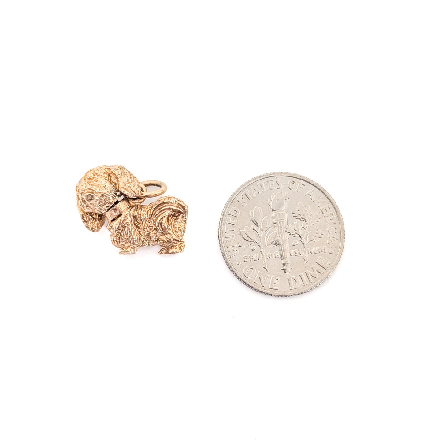 14k Gold Vintage Pekingese mechanical charm next to a U.S. dime coin on a white background