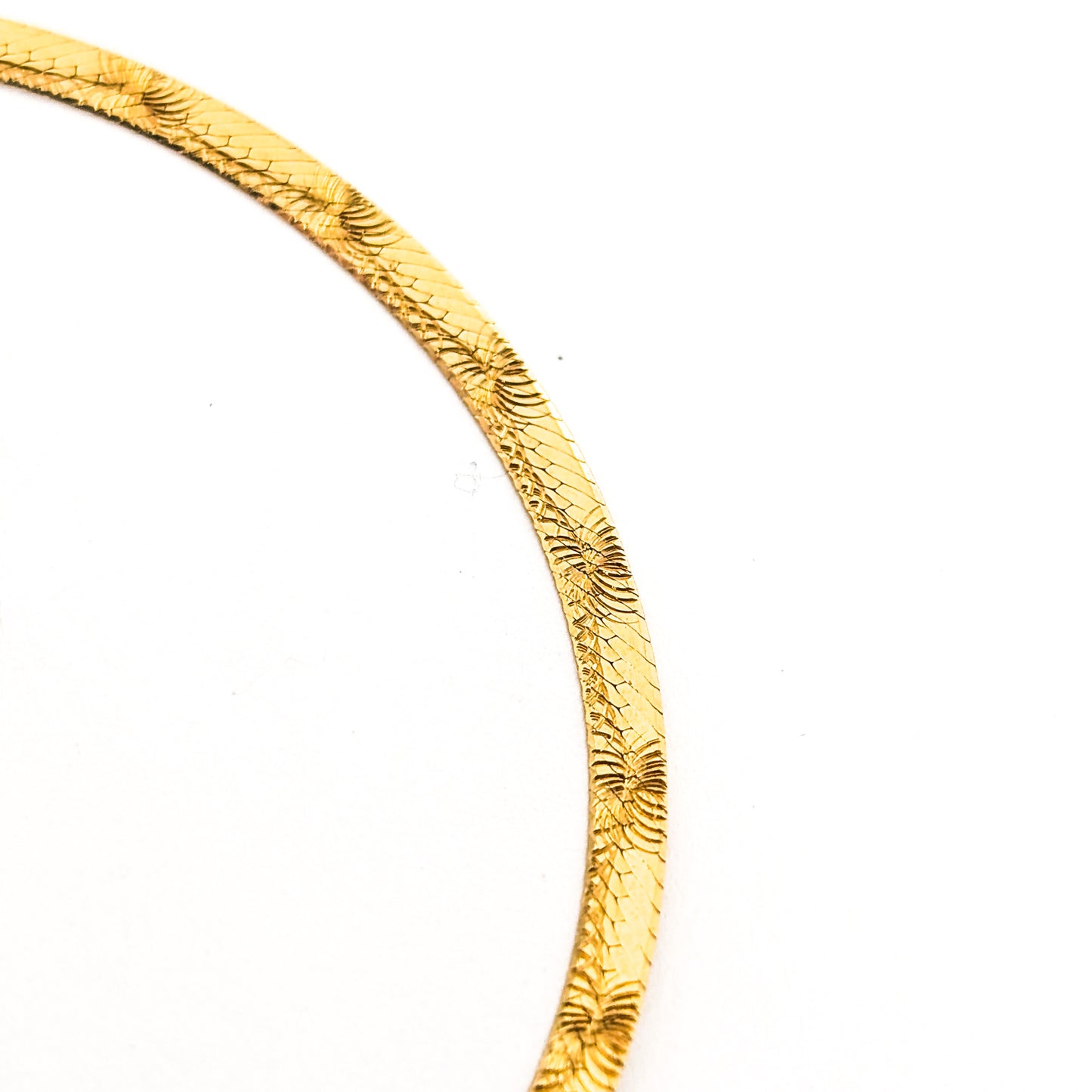 Vintage 14K gold bracelet features an elegant herringbone design with a textured finish on a white background
