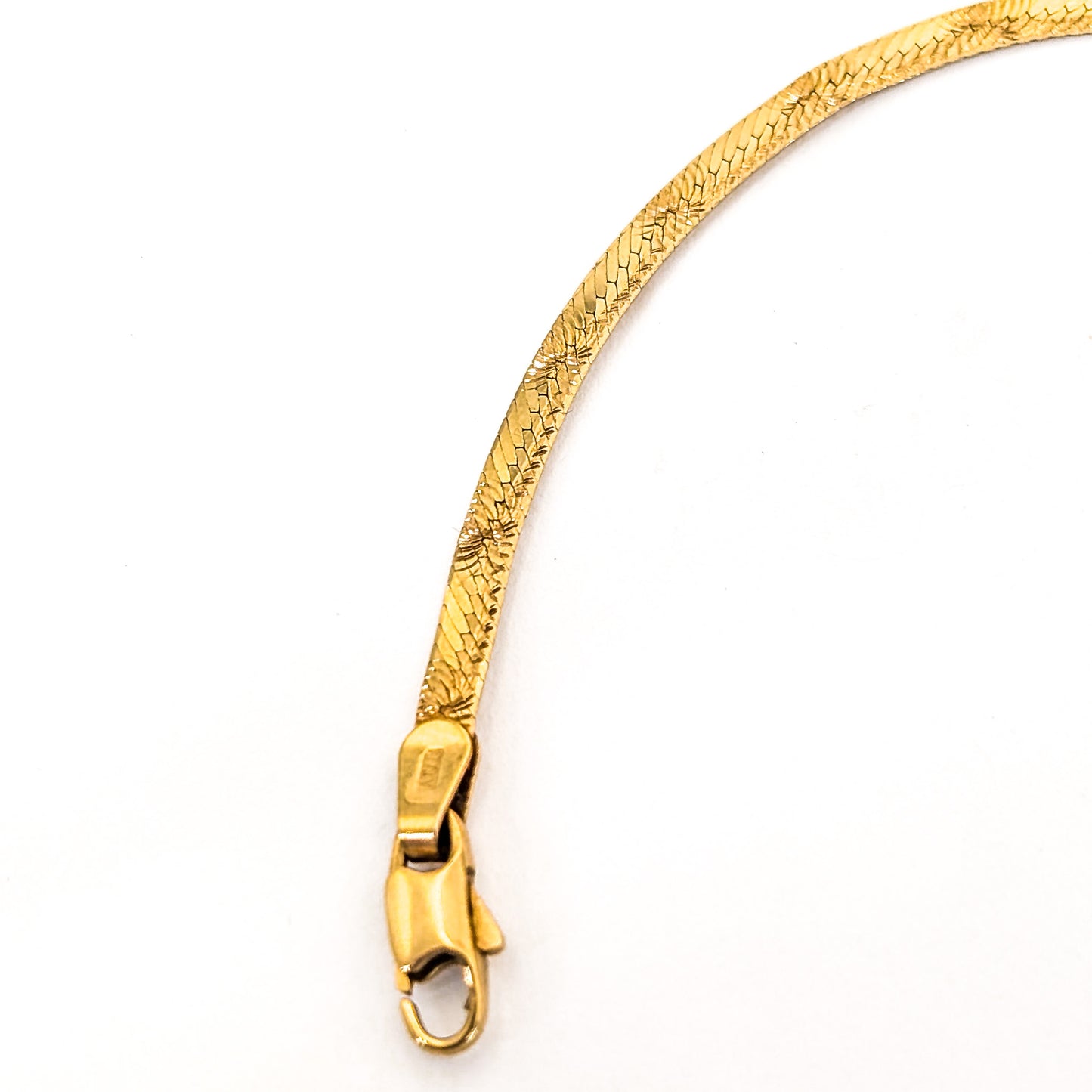 Vintage 14K gold bracelet features an elegant herringbone design with a textured finish on a white background