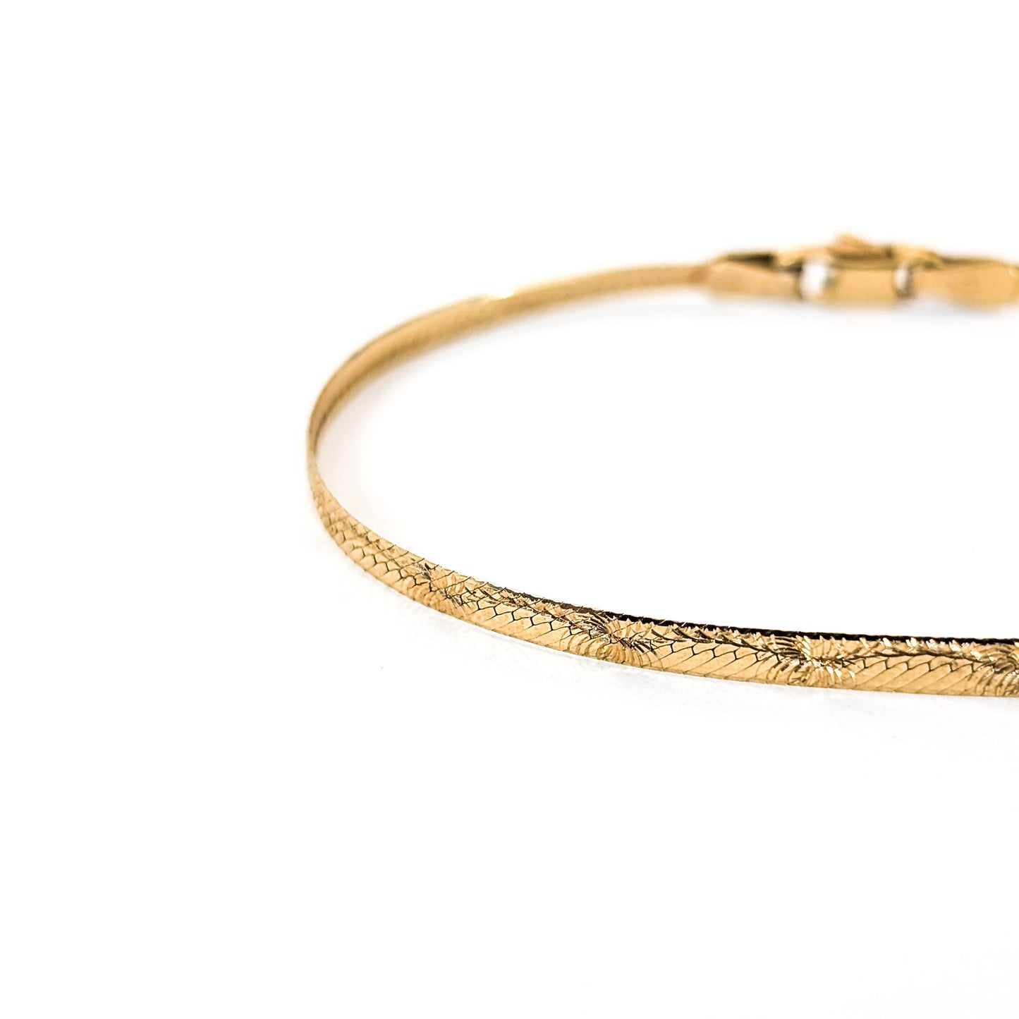 Vintage 14K gold bracelet features an elegant herringbone design with a textured finish on a white background