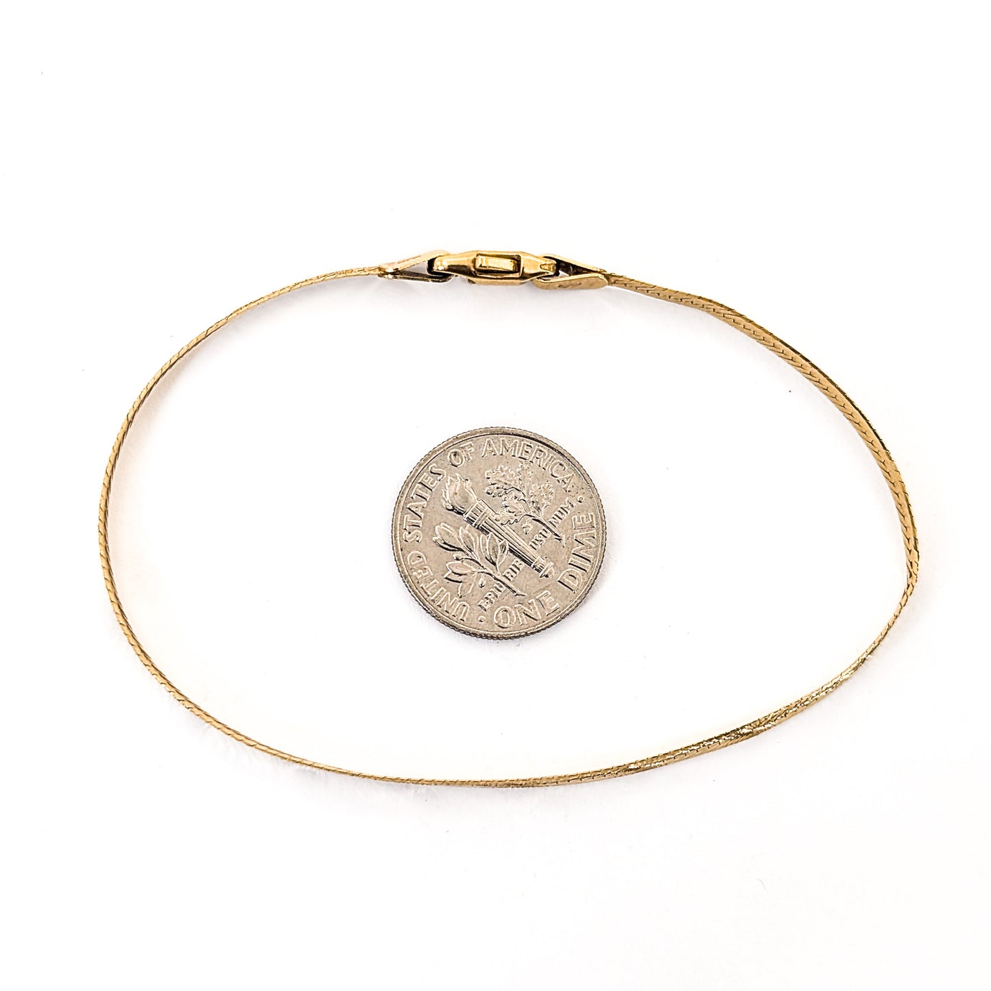 Vintage 14K gold bracelet features an elegant herringbone design with a textured finish on a white background
