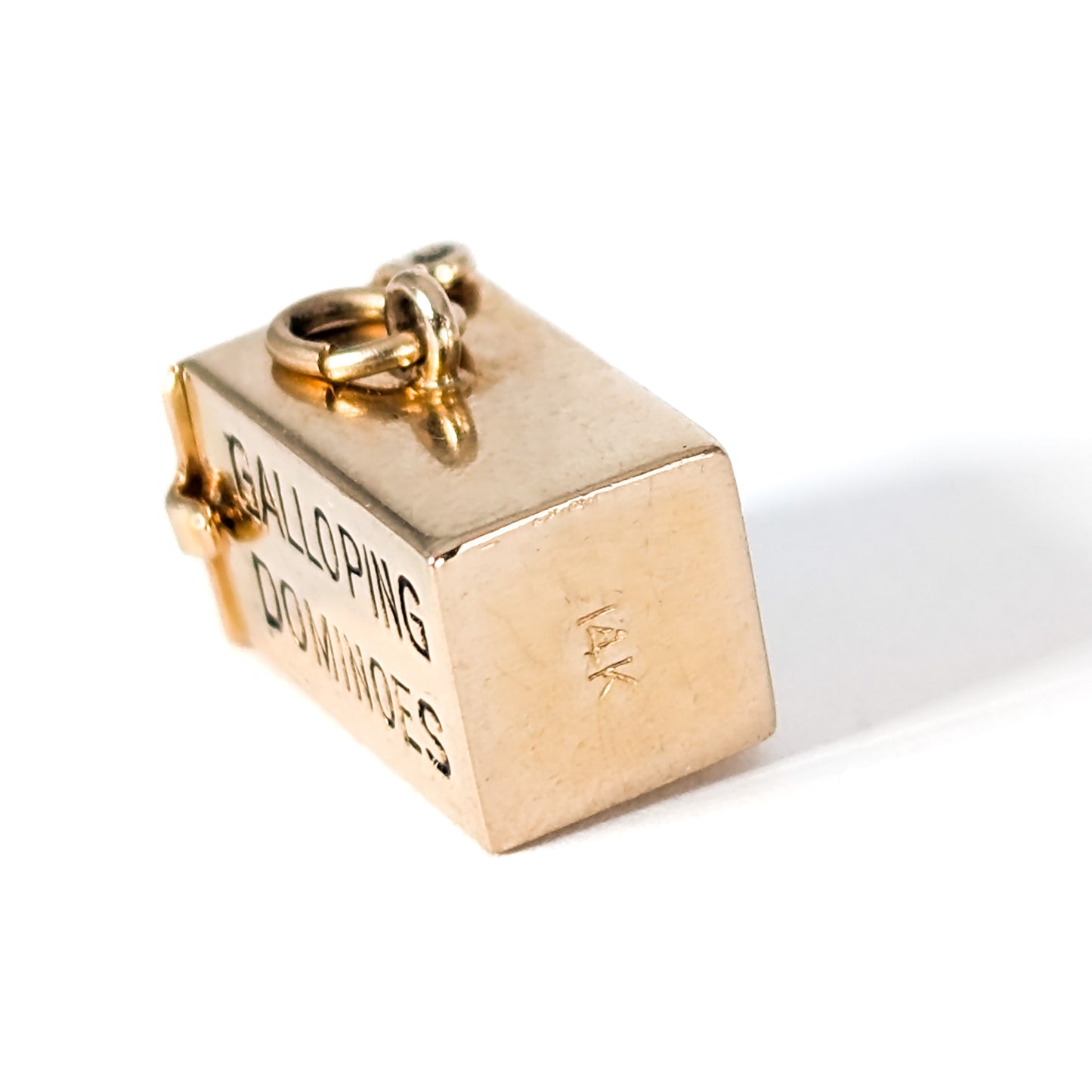 14K Gold mechanical charm pendent with 'Galloping Dominoes' text and with hidden Bakelite dice on a white background