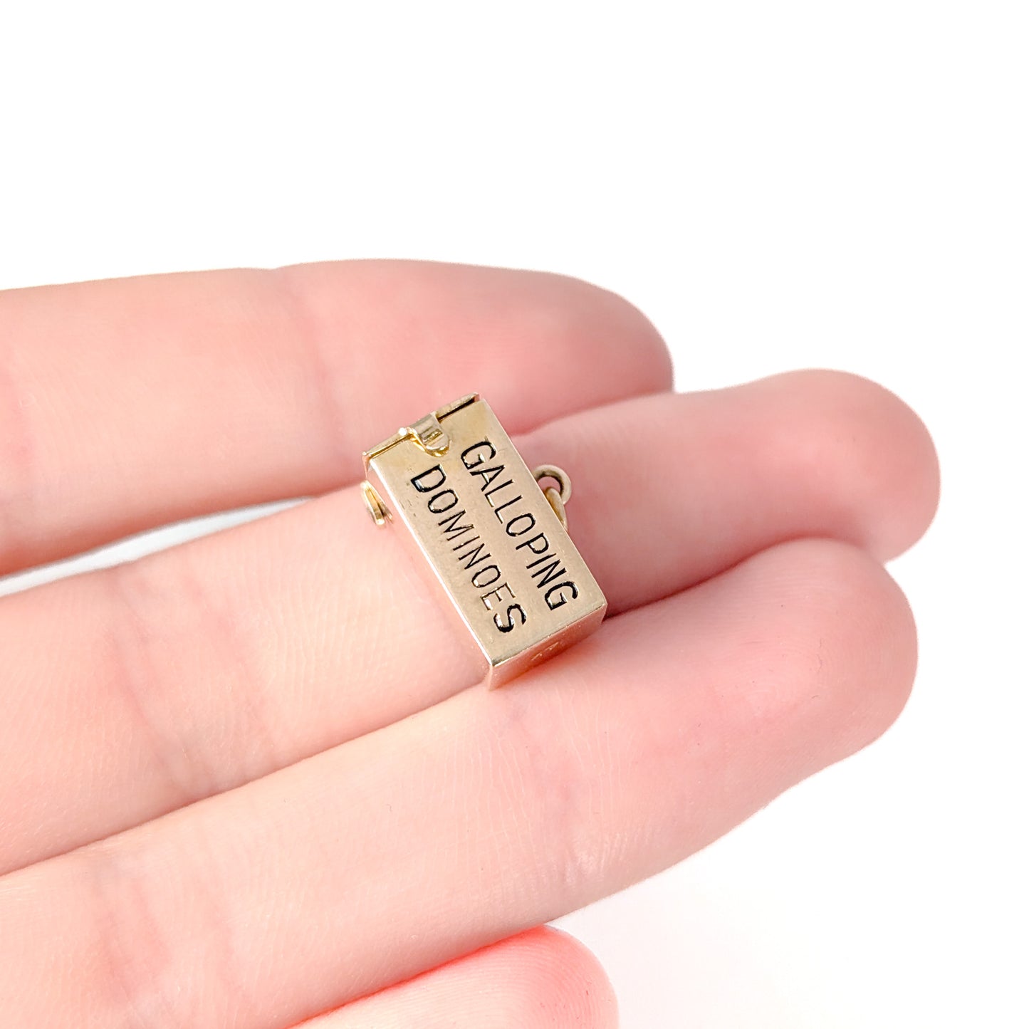 14K Gold mechanical charm pendent with 'Galloping Dominoes' text and with hidden Bakelite dice on a white background