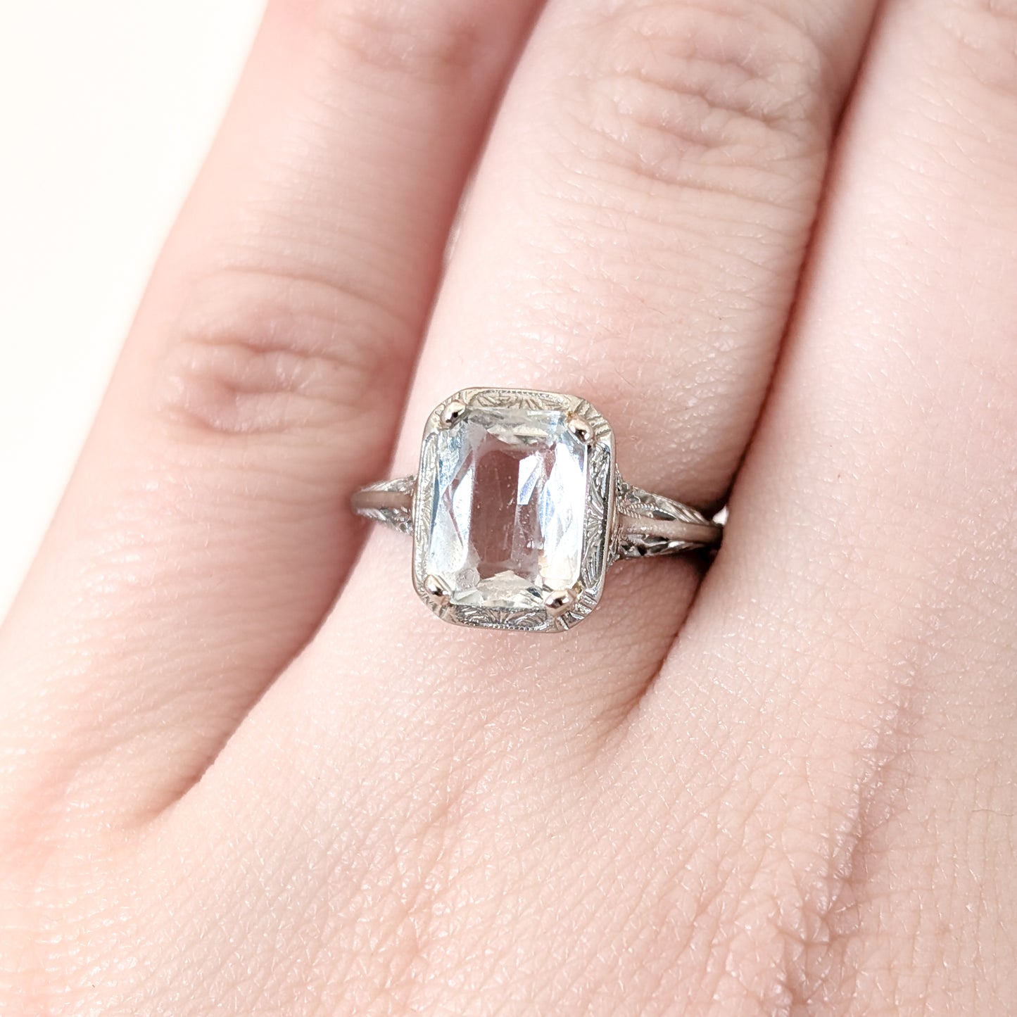 18k white gold ring with a rectangular aquamarine gemstone on a white background