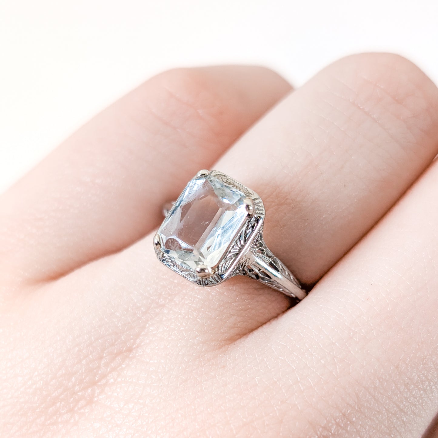18k white gold ring with a rectangular aquamarine gemstone on a white background