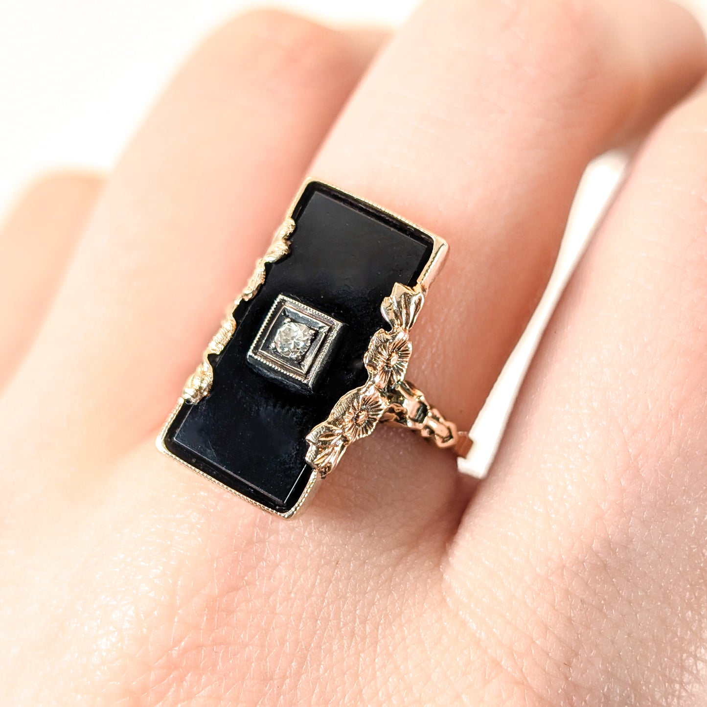 10K Gold Onyx ring on a finger against a white background