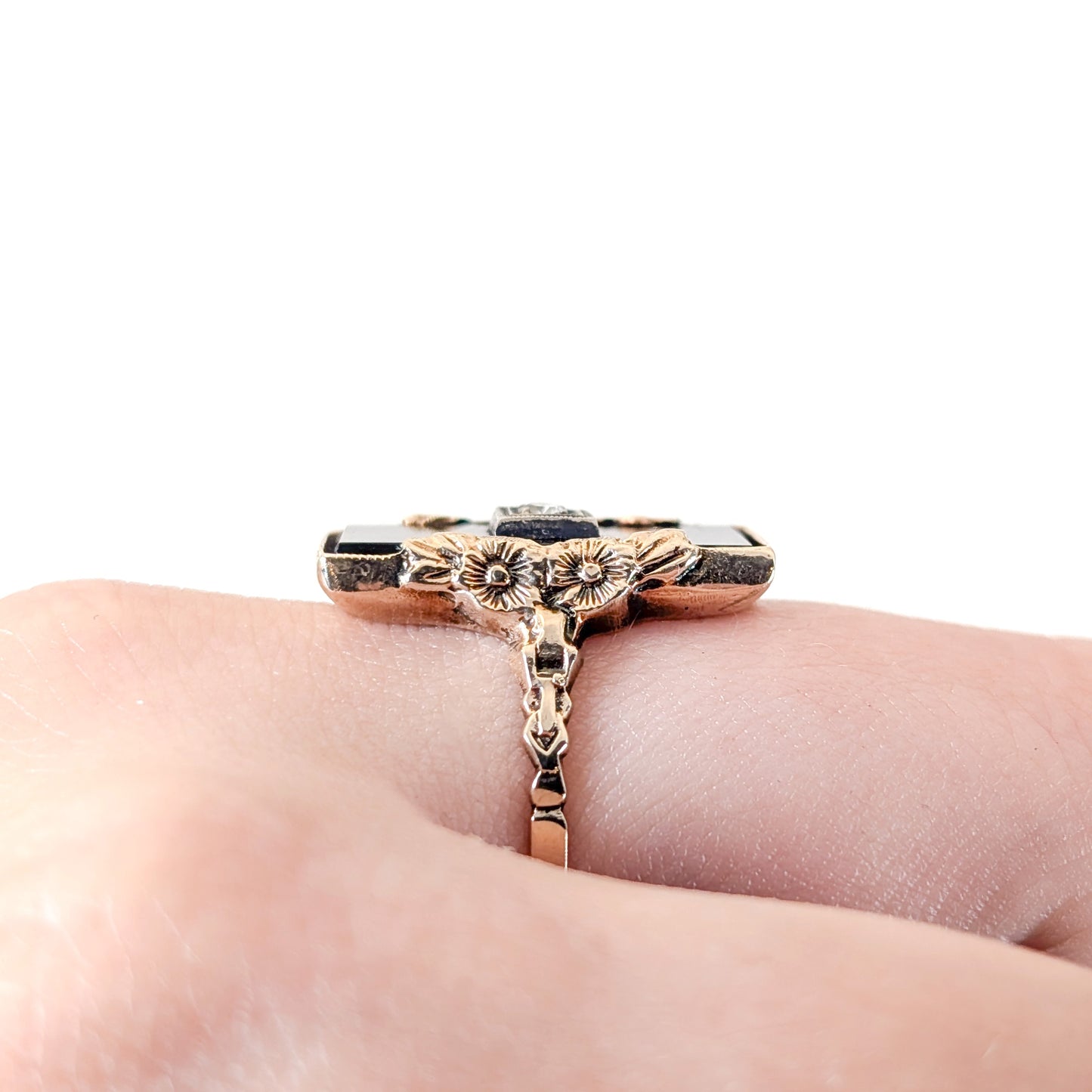 10K Gold Onyx ring on a finger against a white background