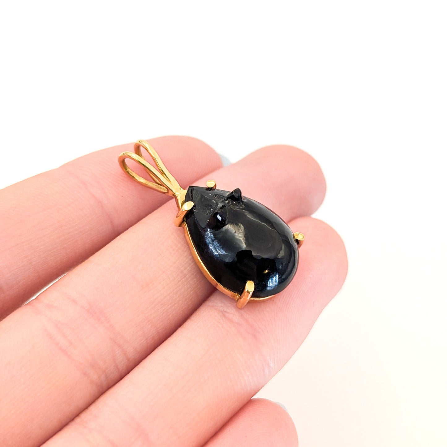 Black onyx teardrop pendant carved in a mouse with 14k gold setting on a white background