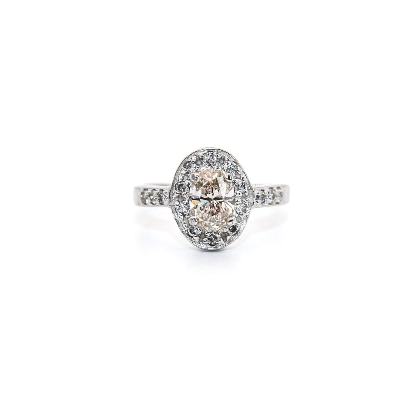 A 14K white gold diamond engagement solitaire ring with a central diamond surrounded by a halo of smaller diamonds, displayed against a white background.