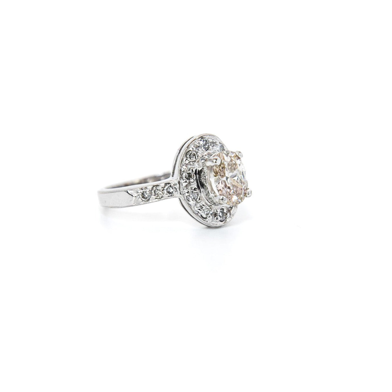 A 14K white gold diamond engagement solitaire ring with a central diamond surrounded by a halo of smaller diamonds, displayed against a white background.