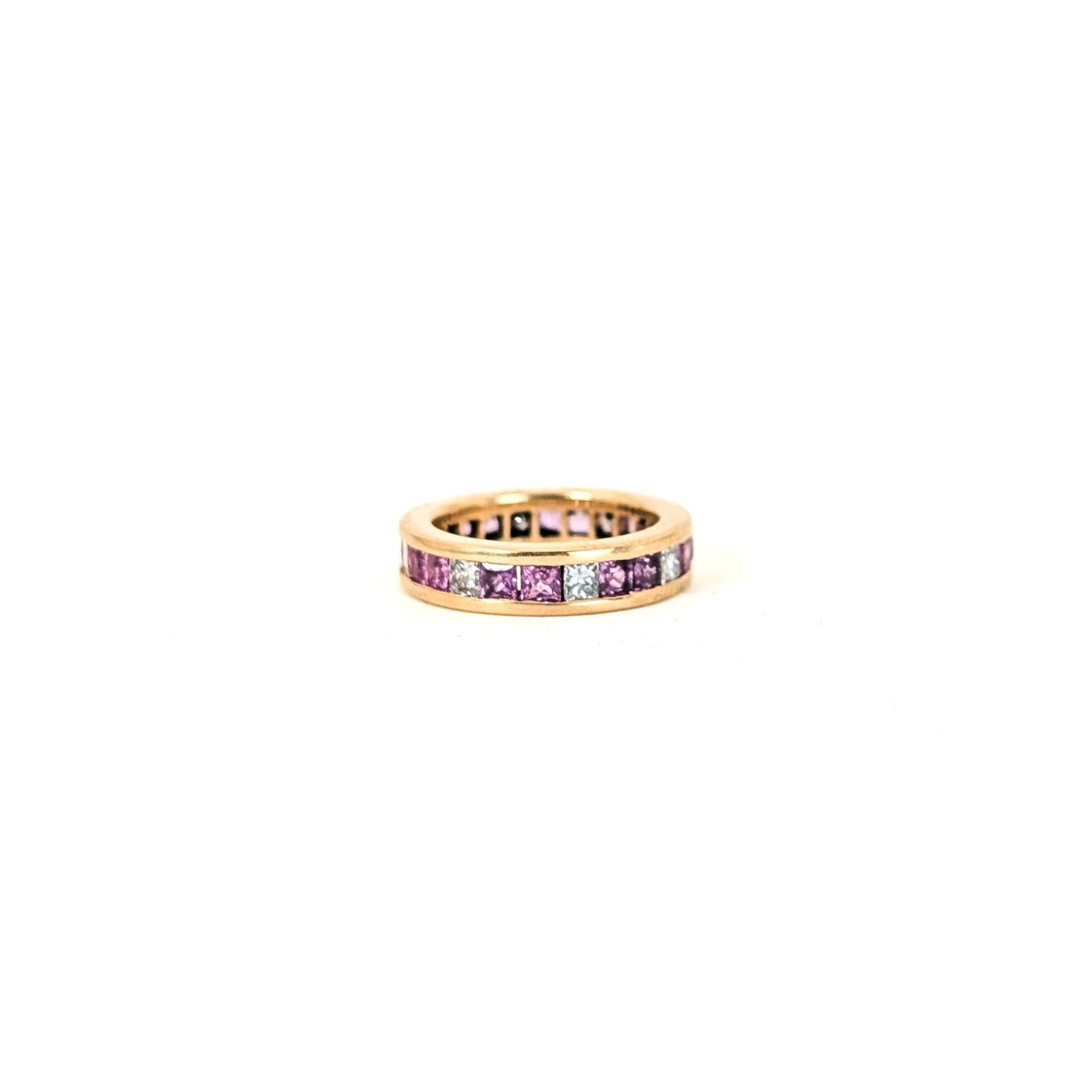 14k gold eternity band with pink sapphires and diamonds on a white background