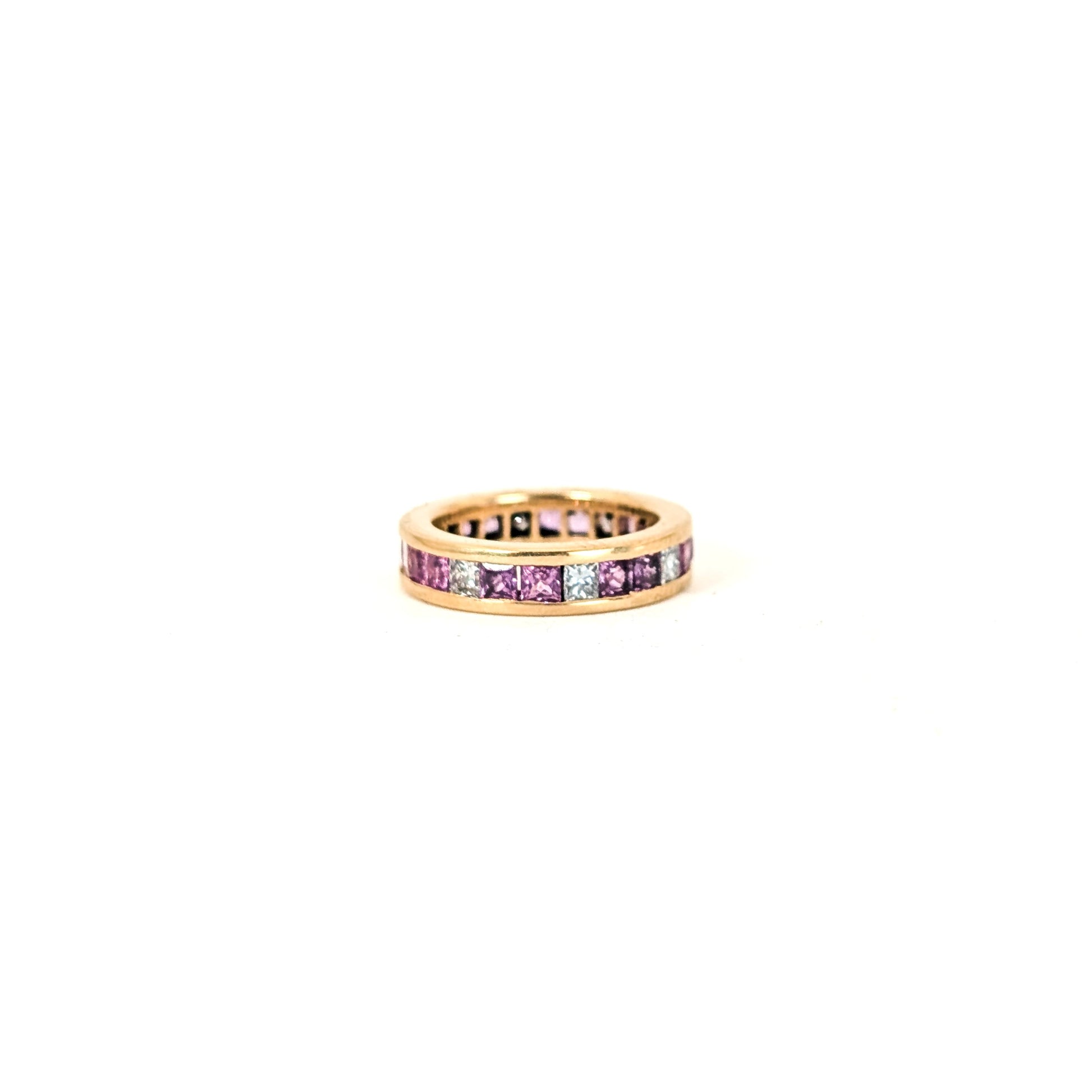 14k gold eternity band with pink sapphires and diamonds on a white background