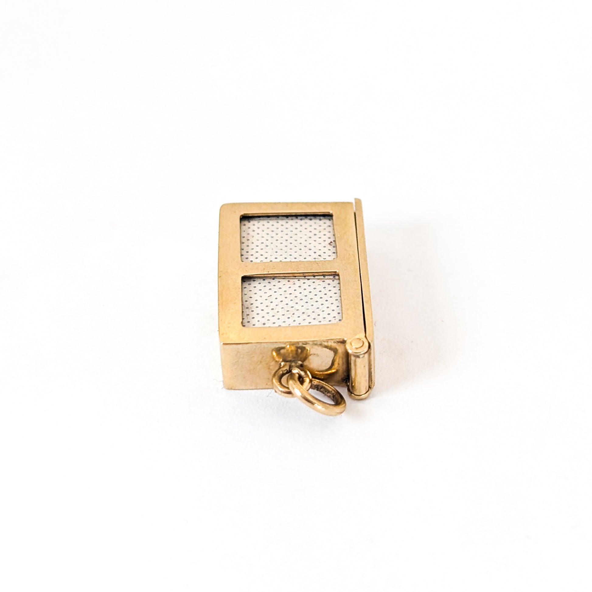 14k gold vintage mechanical charm with enameled card suit symbols and a real deck of cards on a white background