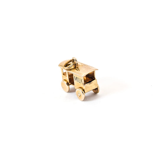 14K Gold milk cart mechanical charm on a white background