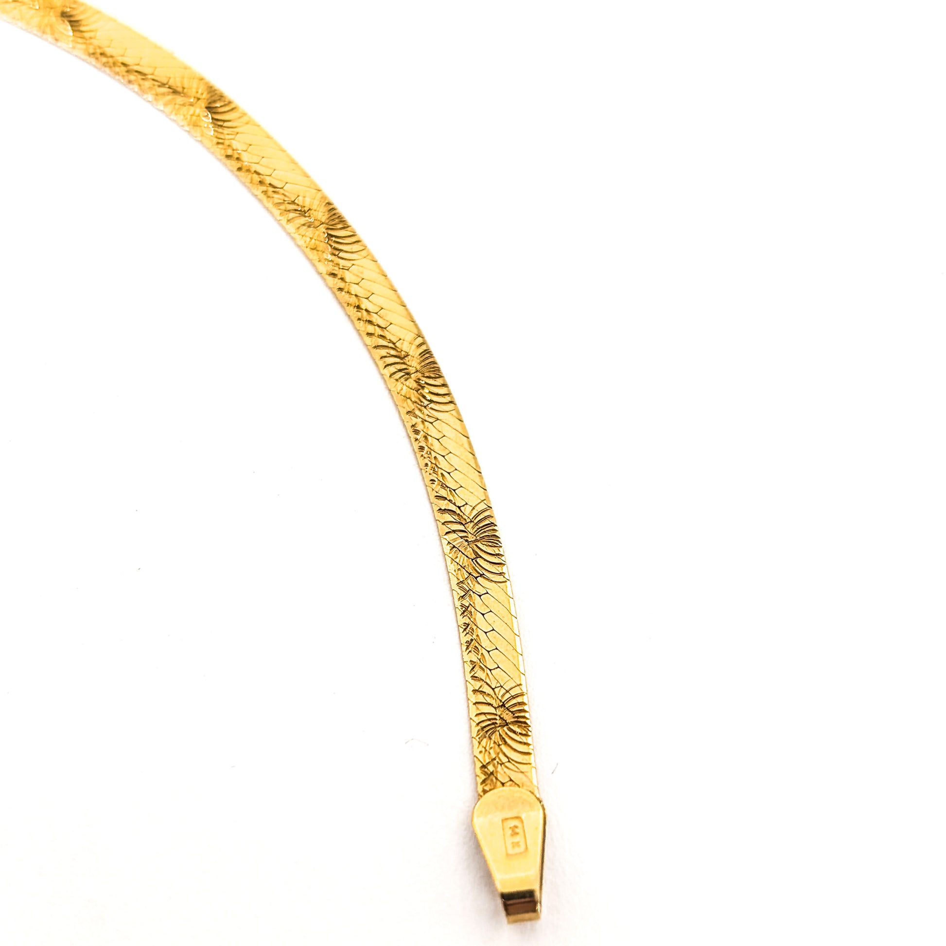 Vintage 14K gold bracelet features an elegant herringbone design with a textured finish  on a white background