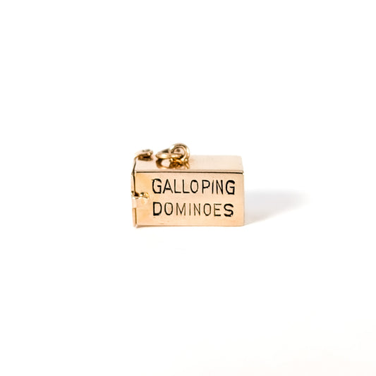14K Gold mechanical charm pendent with 'Galloping Dominoes'   text and with hidden Bakelite dice on a white background