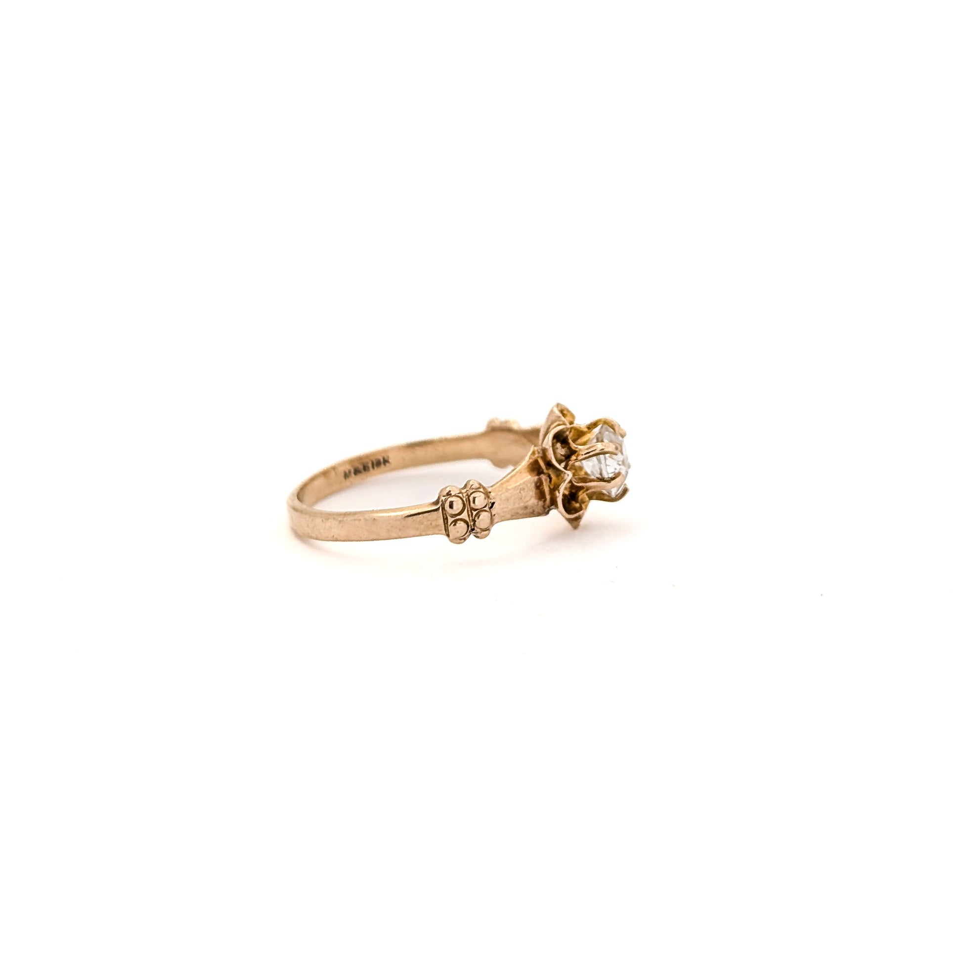 10k Gold ring with a diamond on a white background