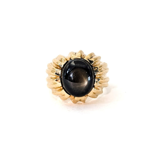 14K gold ring with a black star sapphire gemstone on a white background