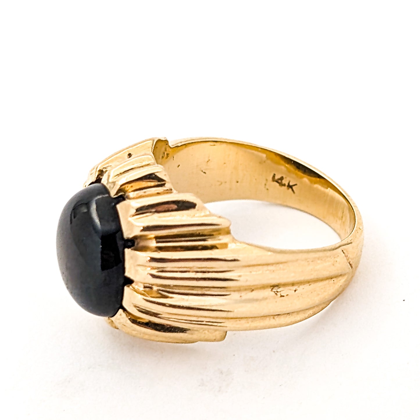 14K gold ring with a black star sapphire gemstone on a white background