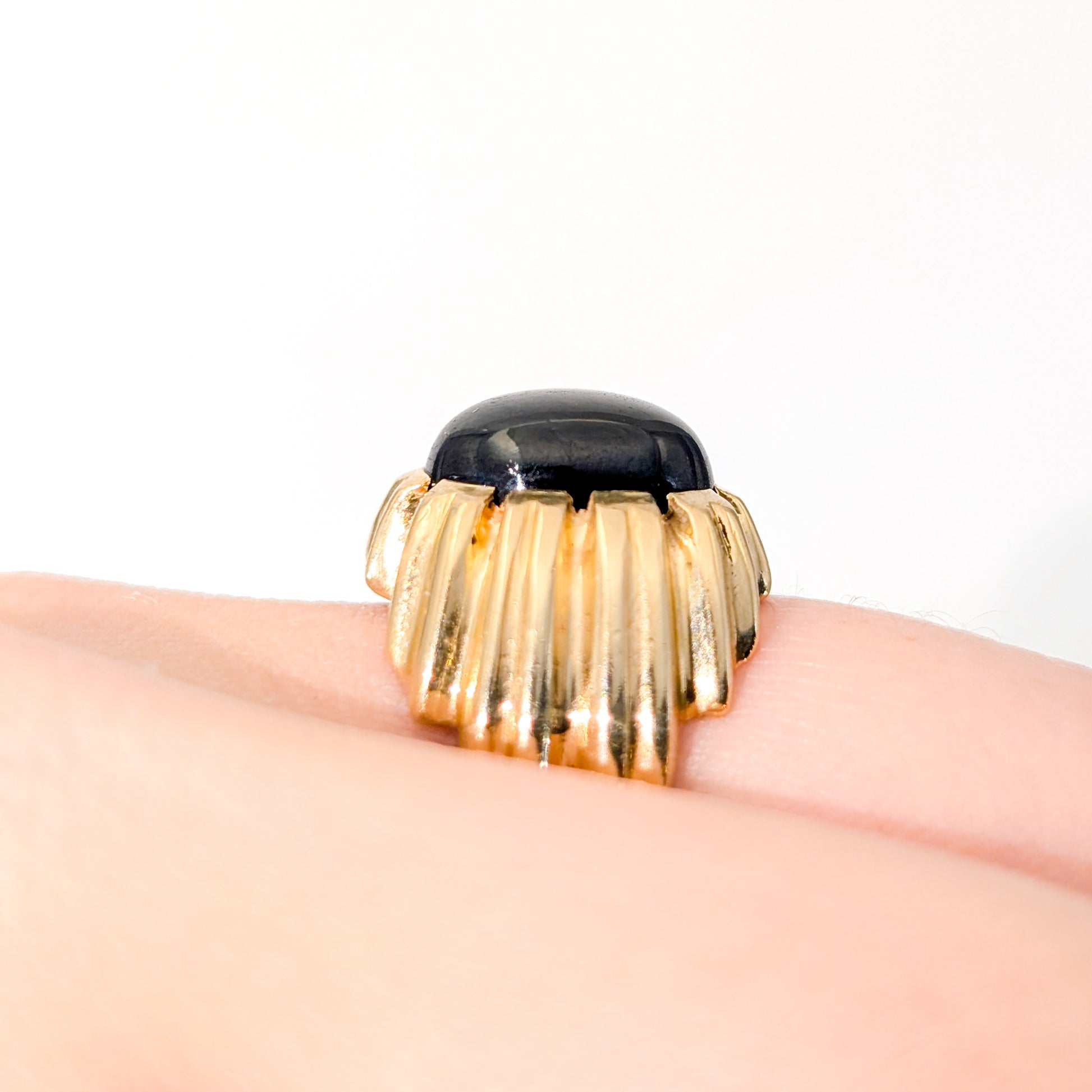 14K gold ring with a black star sapphire gemstone on a white background